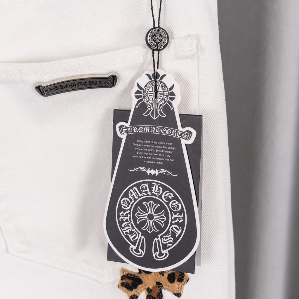 White denim pants with leopard cross patches and belt loop detail