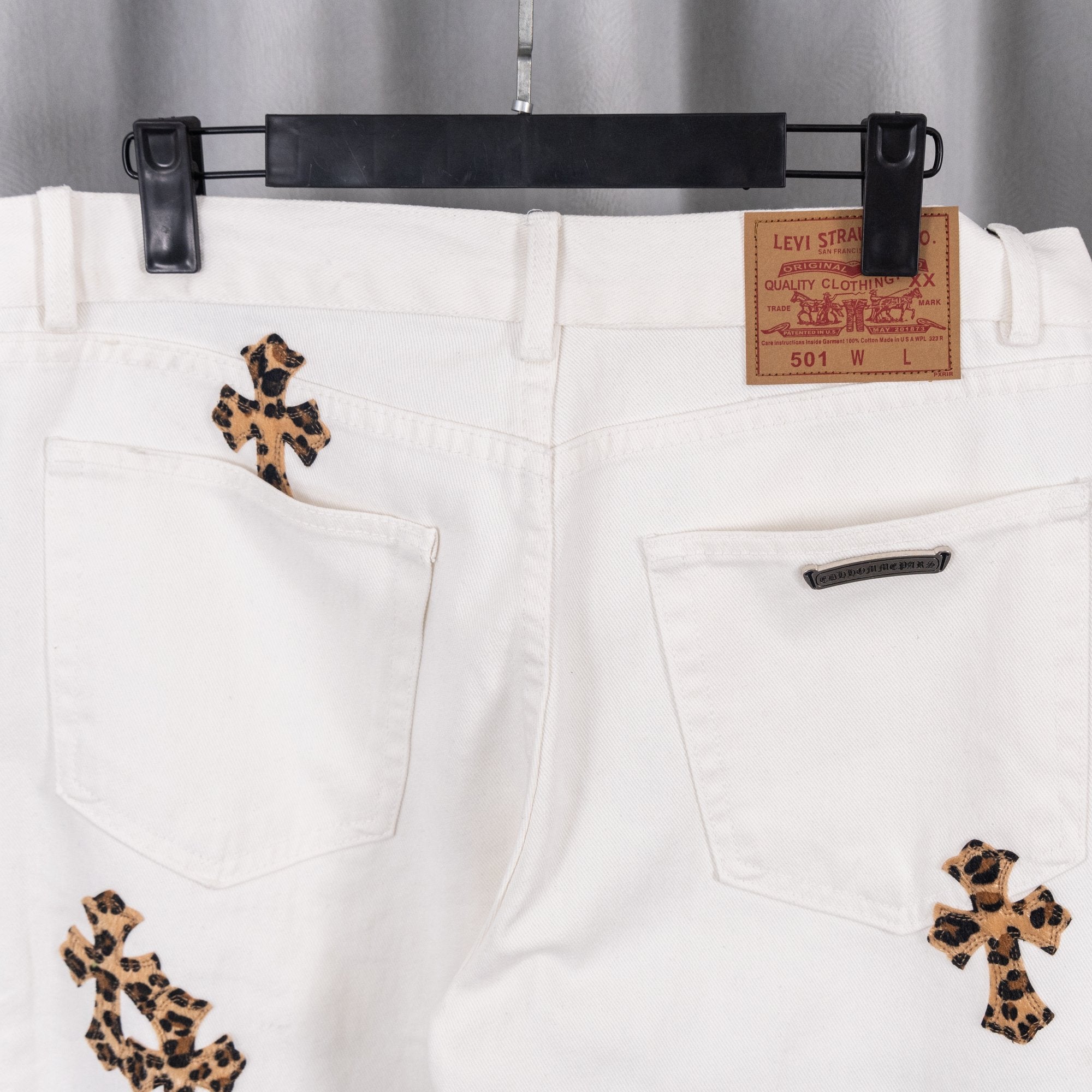 White denim pants with front pockets and leopard patch accents