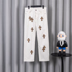 White denim pants with small leopard-print cross patches on the front legs