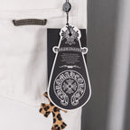 White denim pants with decorative hangtag and leopard-print cross patch