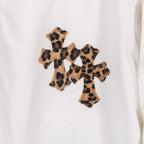 White pants with close-up leopard-print cross appliqué