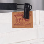 White denim pants with brown leather waistband label