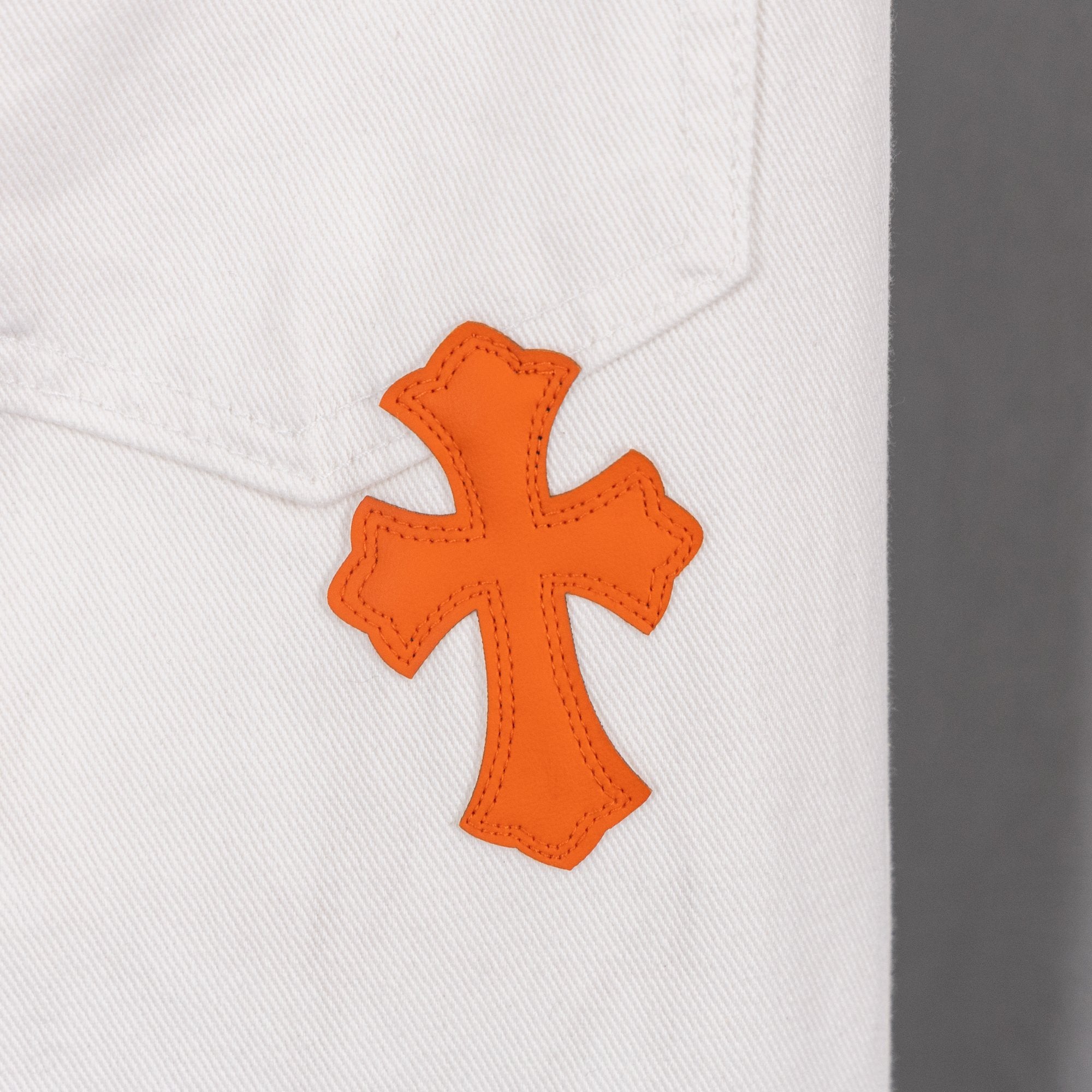 Orange cross applique on white denim pants