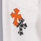 Orange and black cross applique on white denim pants