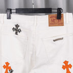 White chrome pants front view with side pockets and orange cross appliqué