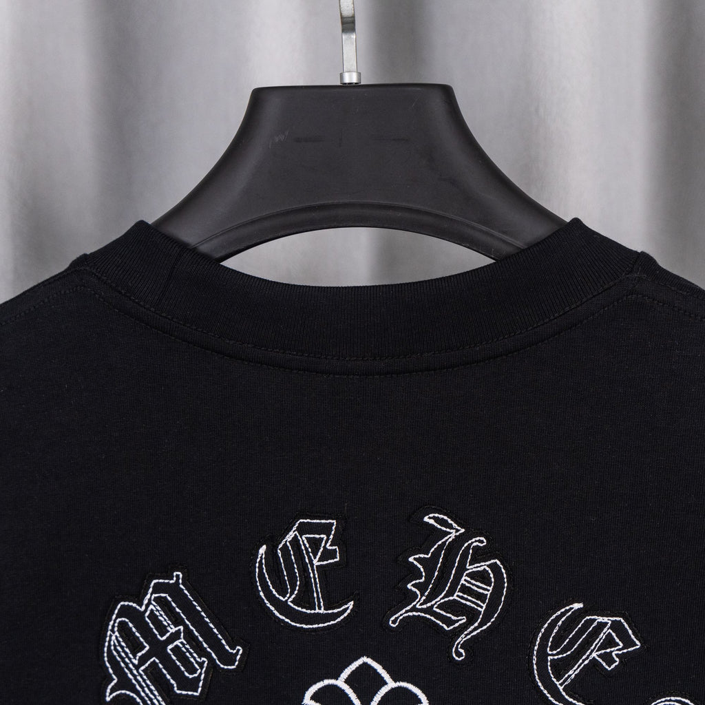 Black crew-neck T-shirt with partial neckline and scattered white cross emblems