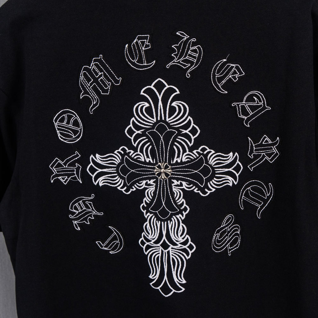 Black short-sleeve T-shirt with large white cross graphic and ornate floral details