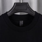 Black crew-neck T-shirt with close-up of ribbed collar and interior tag