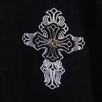 Black T-shirt with detailed white cross emblem featuring a small center gem
