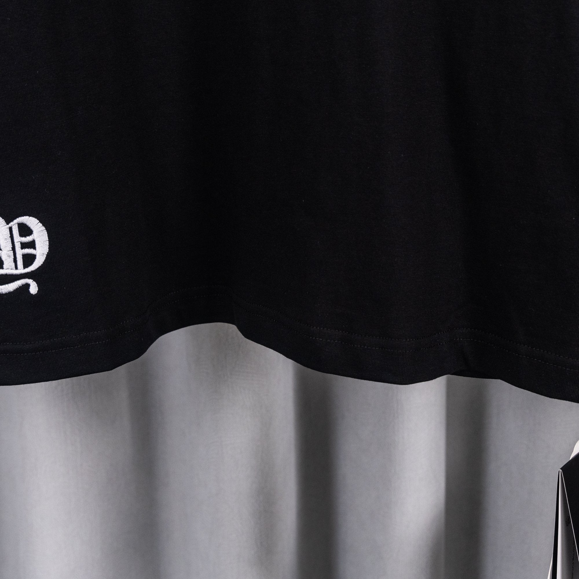 Black short-sleeve T-shirt bottom hem with curved side shape