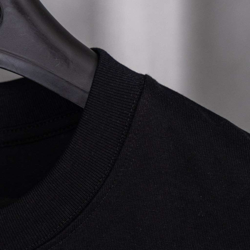 Black crew-neck top with ribbed collar and stitching
