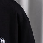 Black crew-neck top with partial white logo graphic