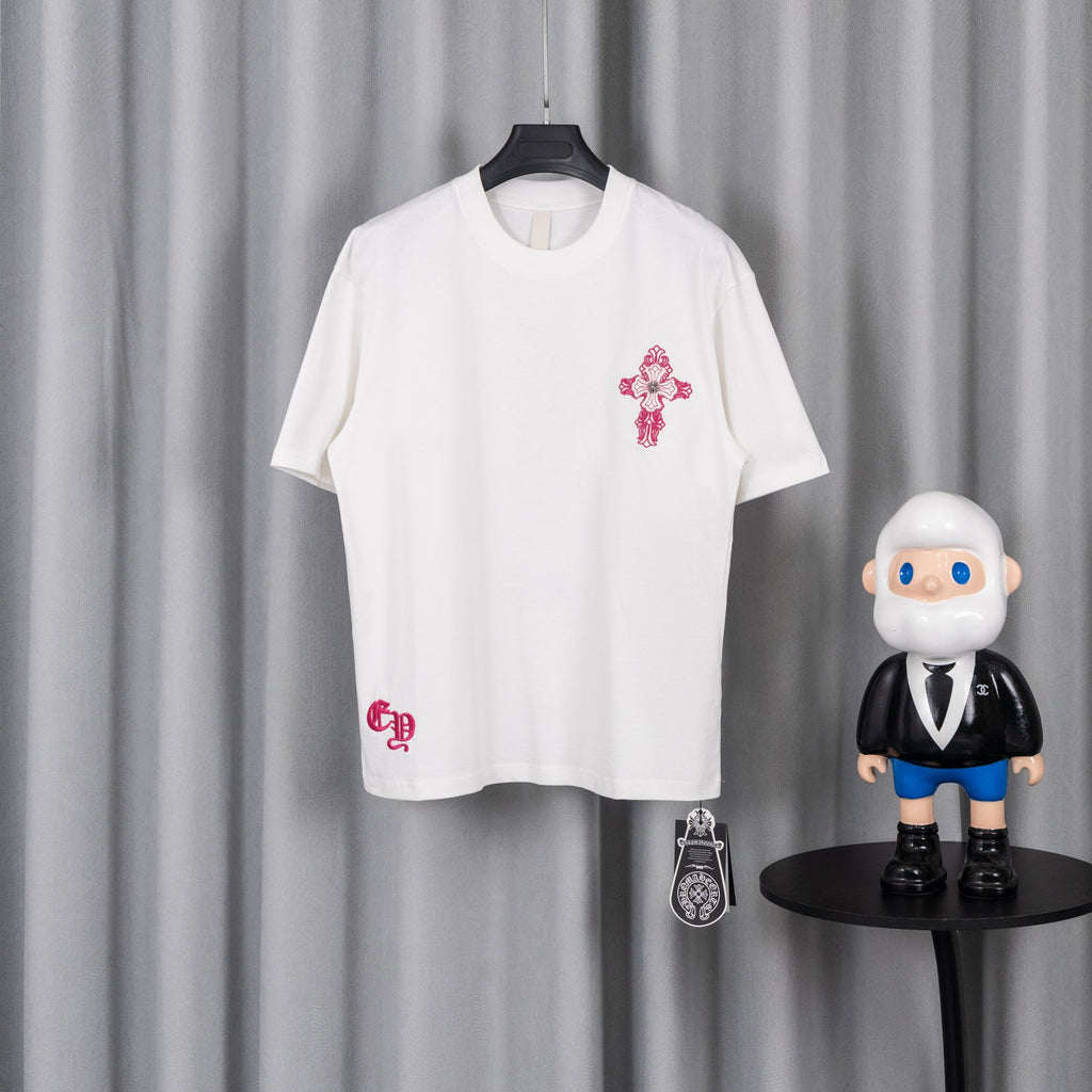 White T-shirt with pink cross emblem on chest and small pink logo on hem
