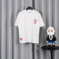 White T-shirt with pink cross emblem on chest and small pink logo on hem