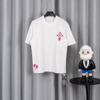 White T-shirt with pink cross emblem on chest and small pink logo on hem