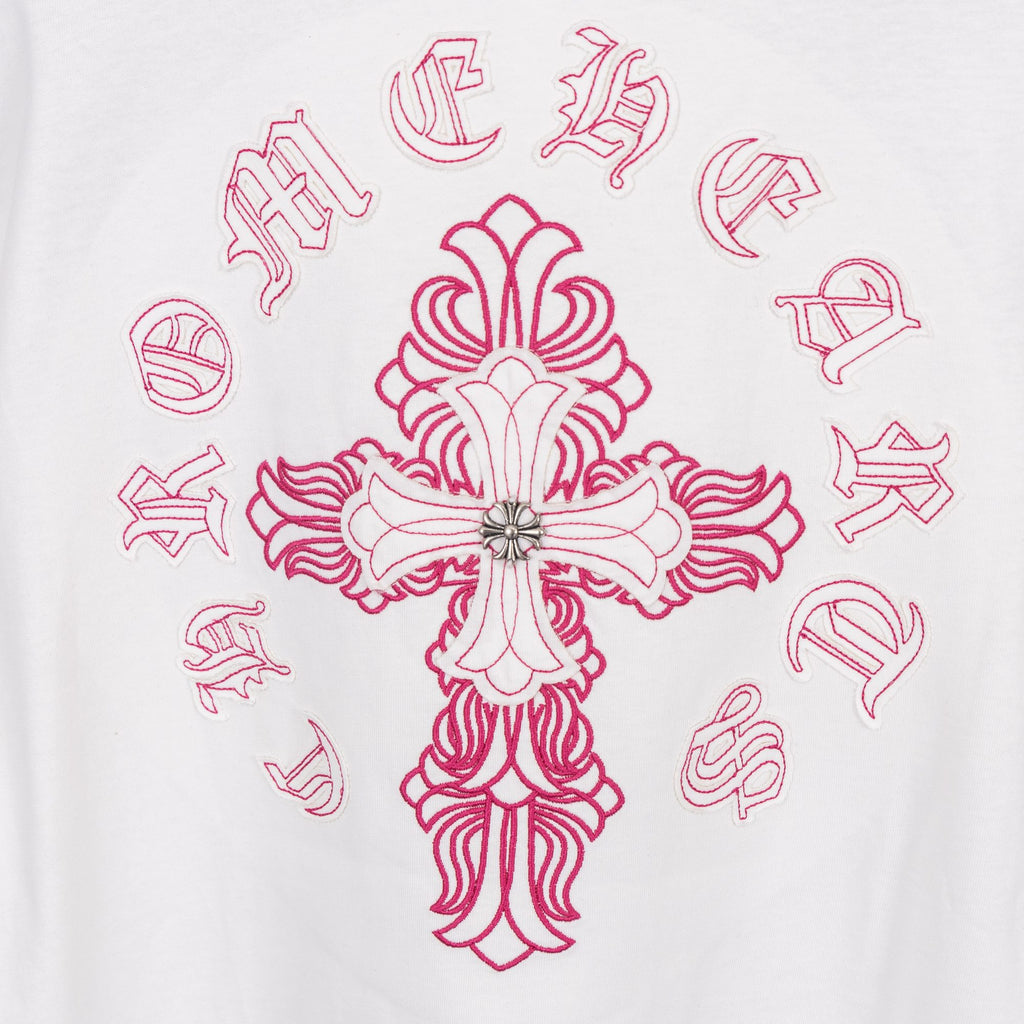White T-shirt with large pink cross embroidery and surrounding symbols