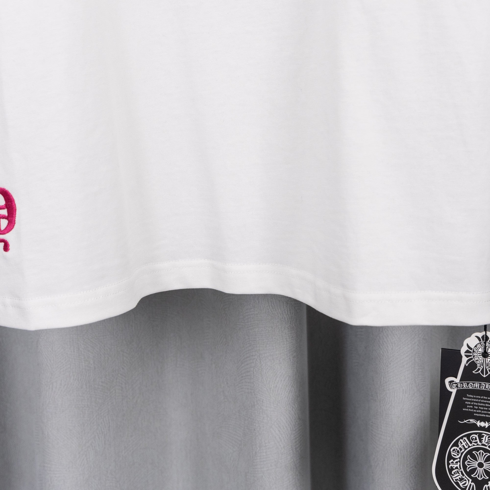 White T-shirt with curved hem and partial pink graphic print