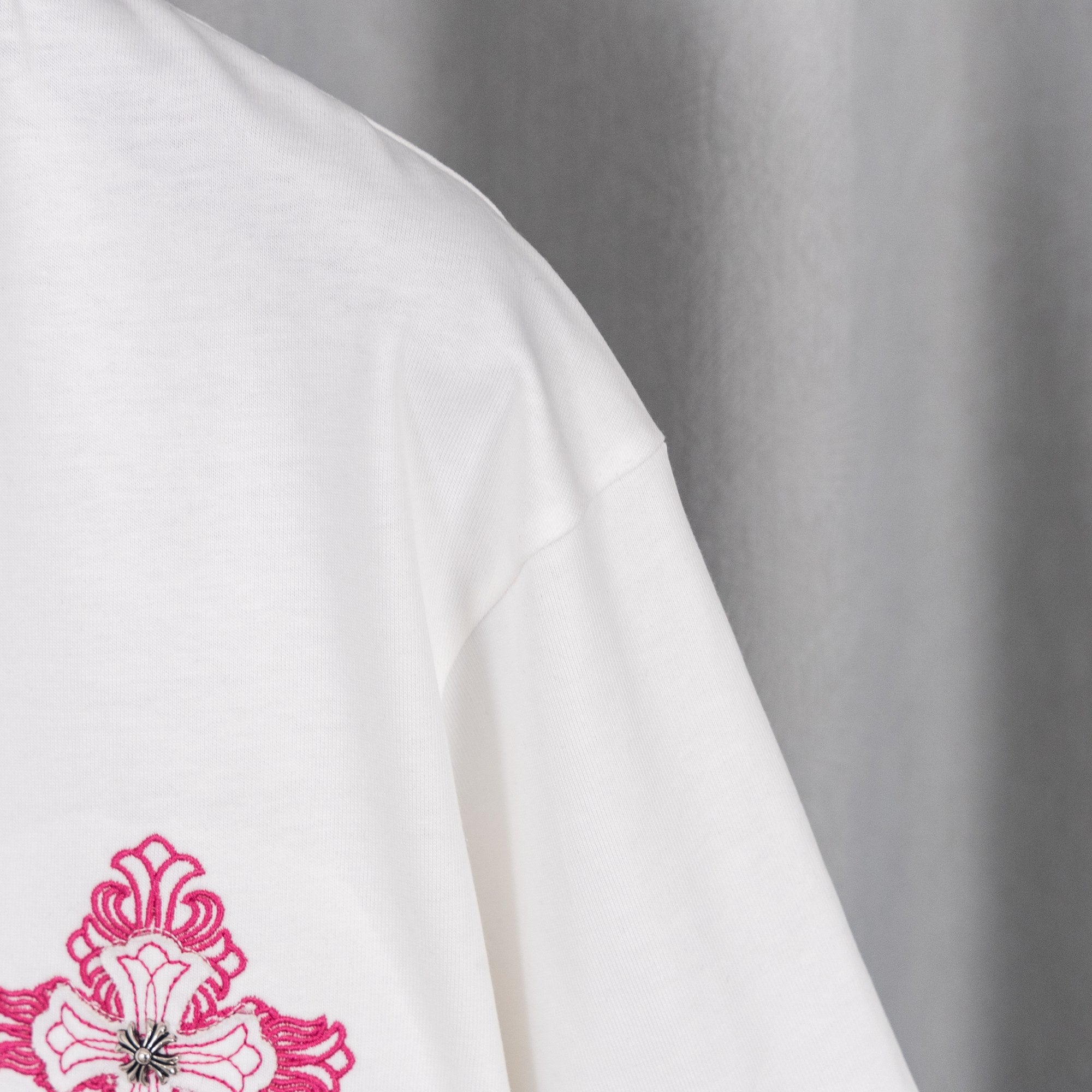 White T-shirt sleeve with magenta floral logo embroidery