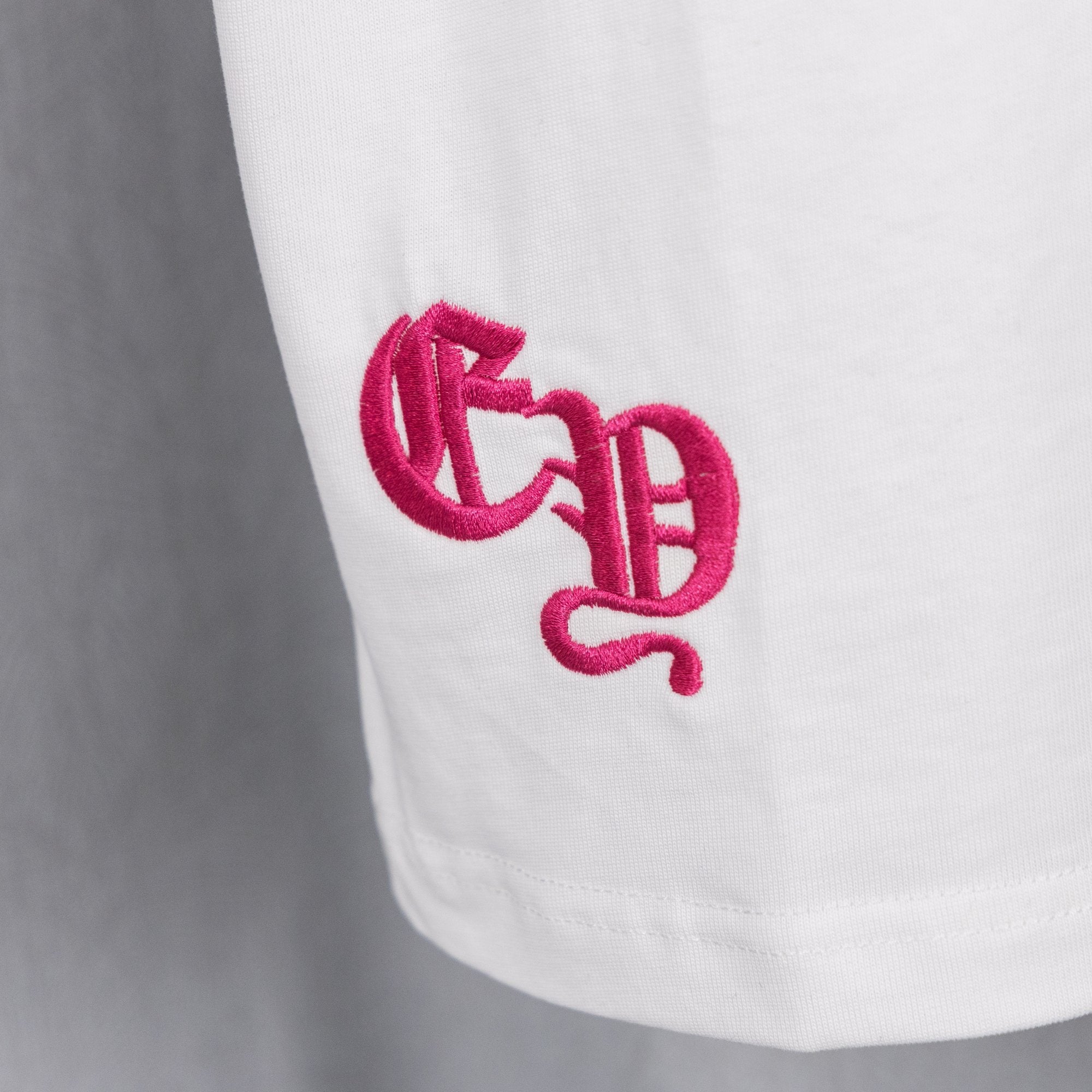 White T-shirt with magenta embroidered logo on chest
