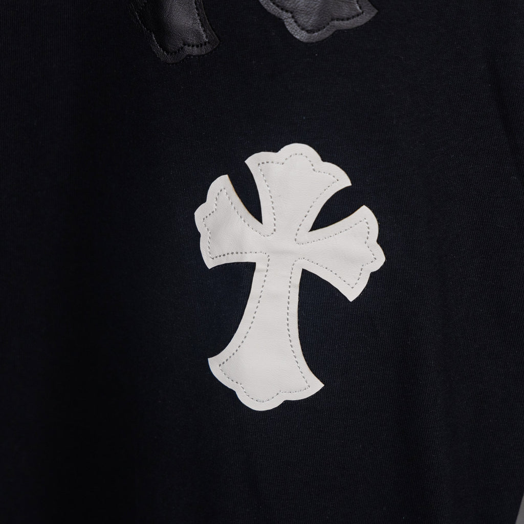Black T-shirt with white cross applique patch, stitched details.