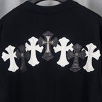 Black T-shirt with large white and gray cross applique on upper back.
