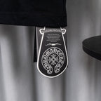 Black garment tag hanging from T-shirt hem.