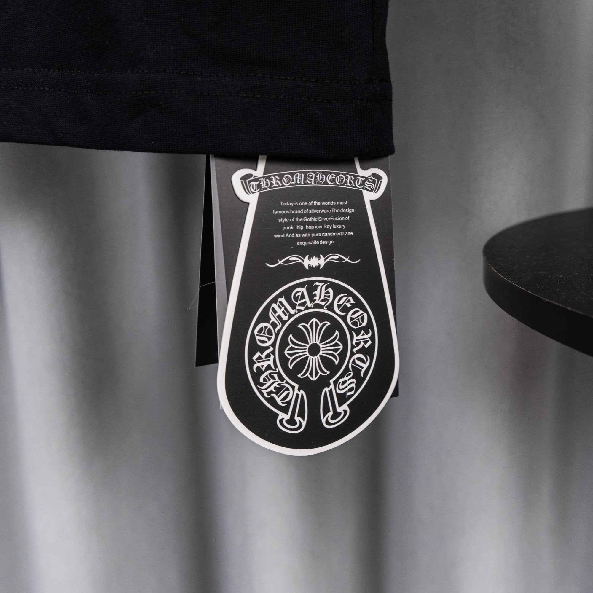 Black garment tag hanging from T-shirt hem.