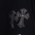 Black T-shirt with dark gray embroidered cross applique cluster.
