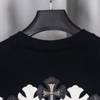 Black T-shirt collar with large cross applique near upper back.