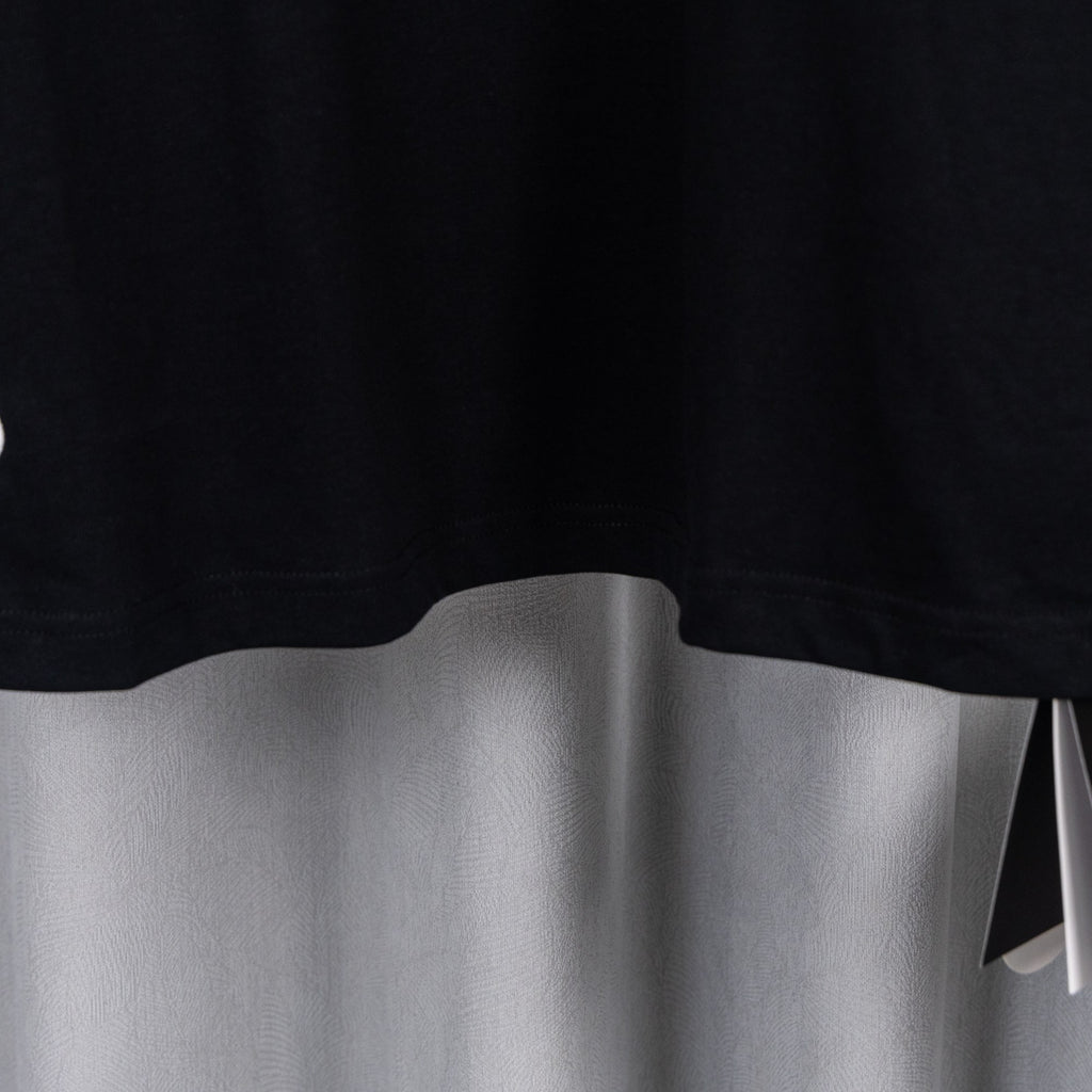 Black short-sleeve T-shirt hem with clean curved bottom edge.