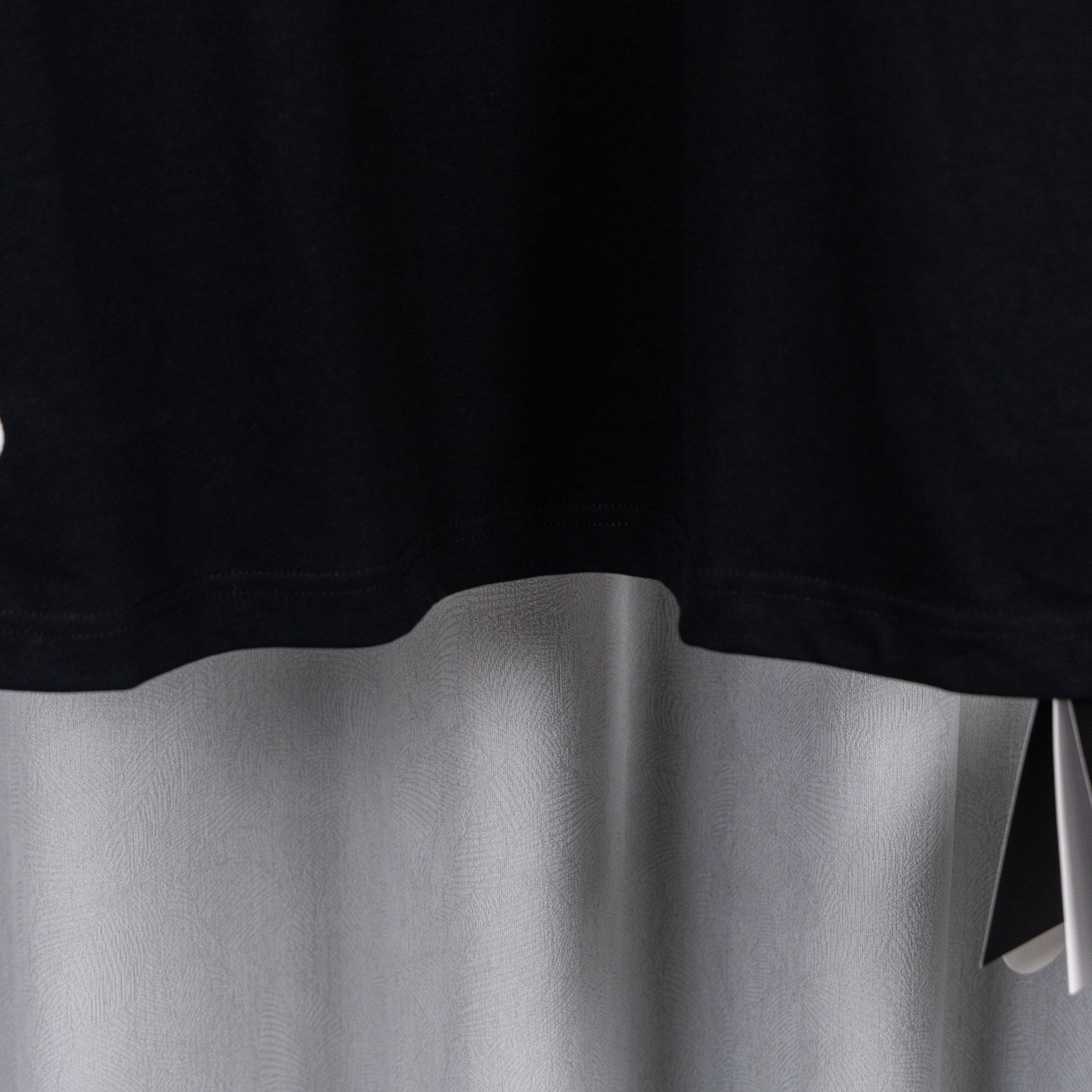 Black short-sleeve T-shirt hem with clean curved bottom edge.
