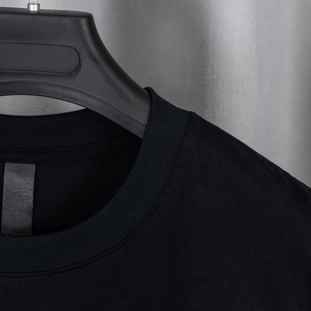 Black short-sleeve shirt neckline with woven label detail