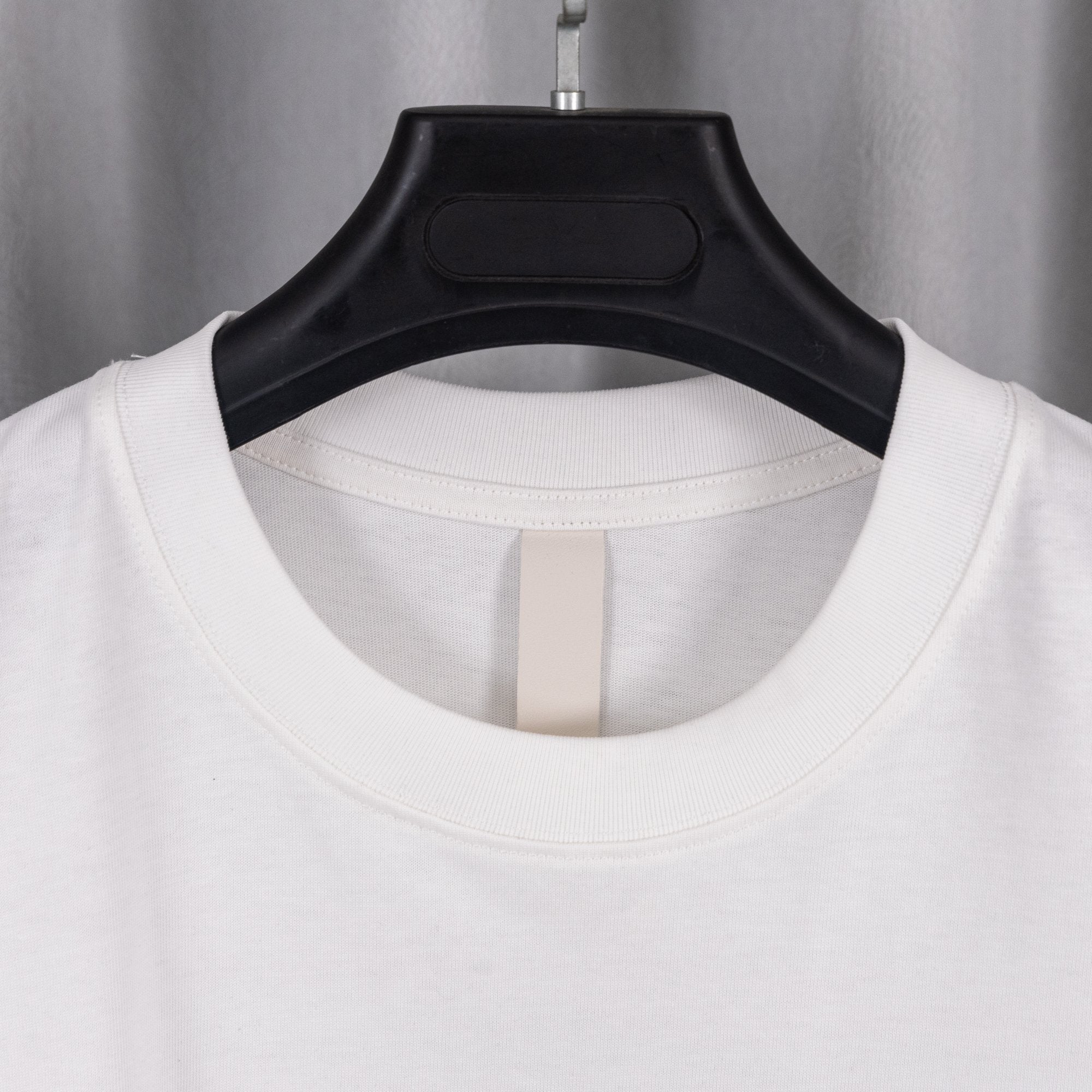 White crewneck T-shirt with ribbed collar opening on black hanger