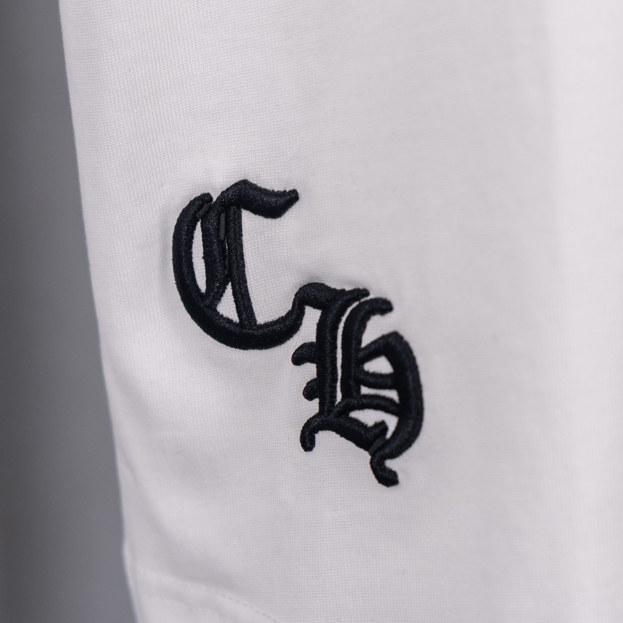White T-shirt close-up of black monogram-style graphic