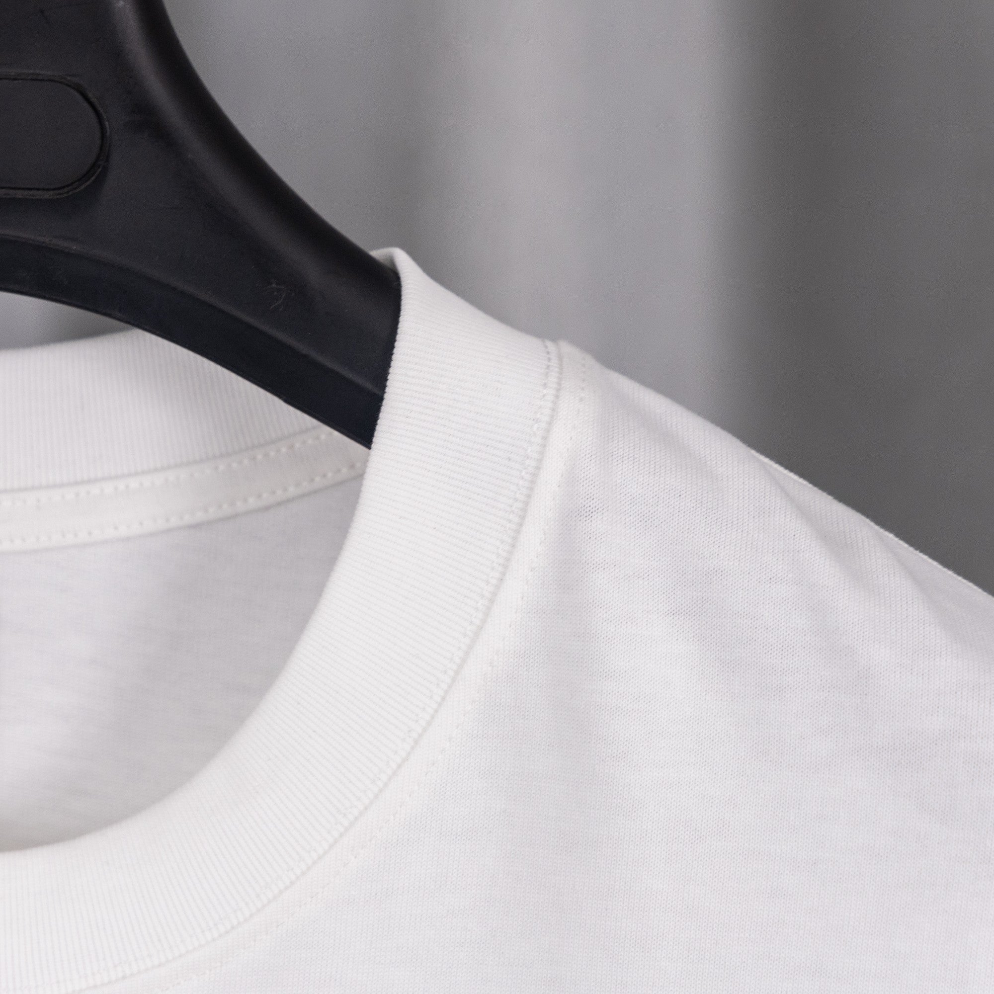 White T-shirt neckline and shoulder seam close-up on hanger