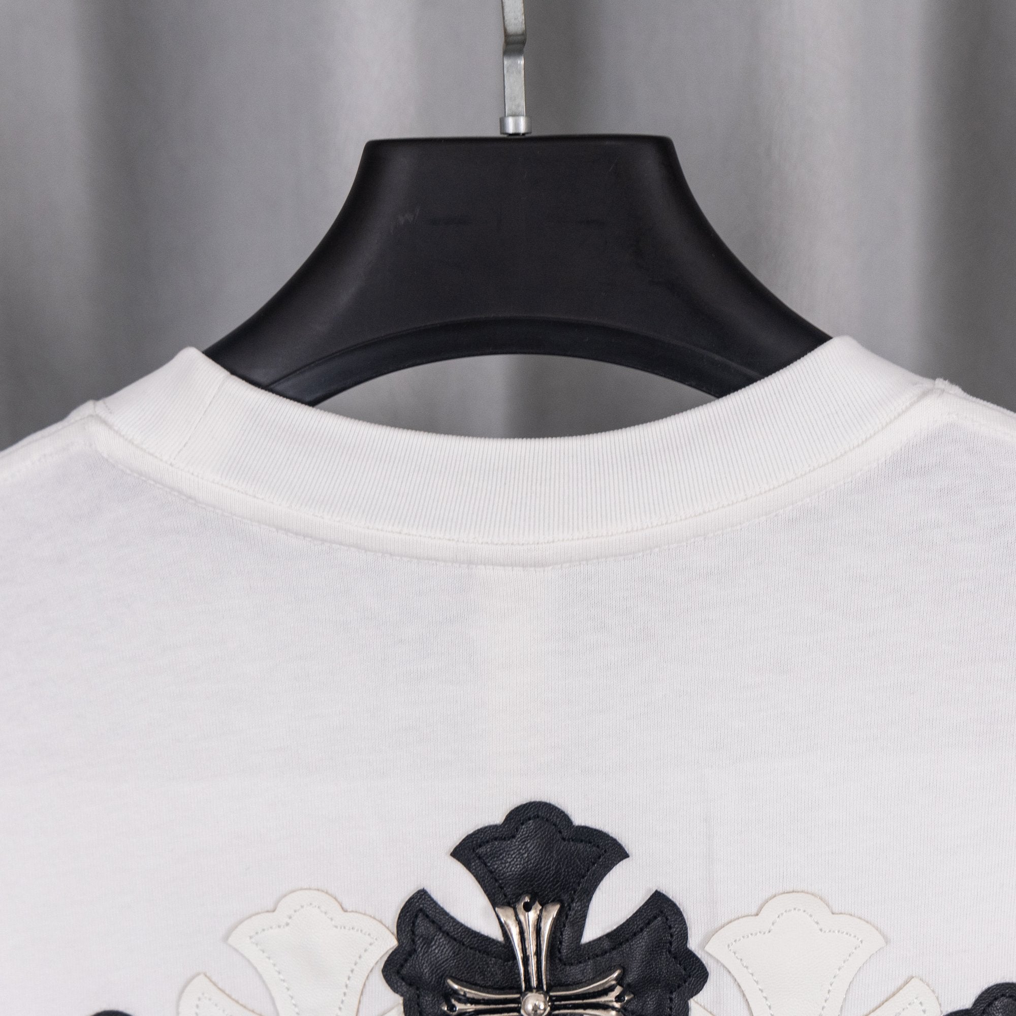 White short-sleeve shirt with black cross crest graphic at chest
