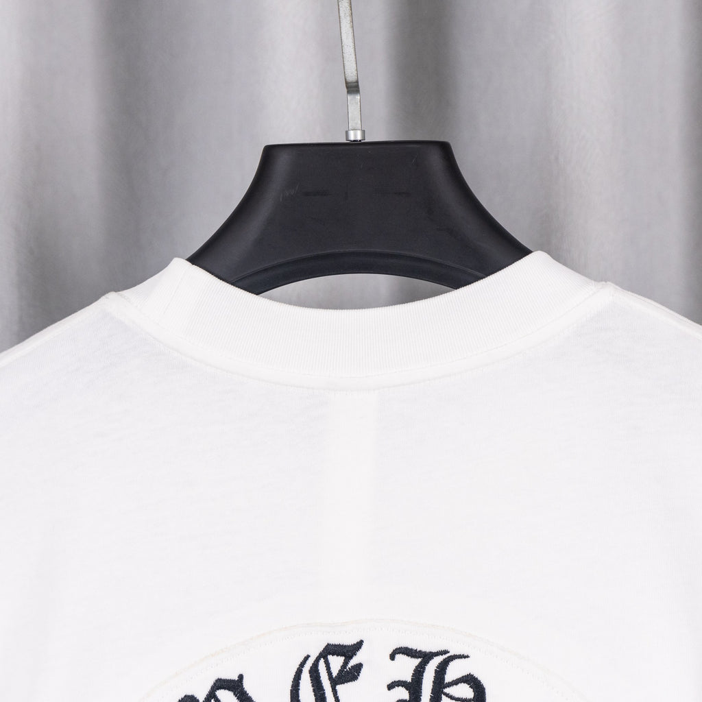 White T-shirt neckline and upper back with dark graphic emblem