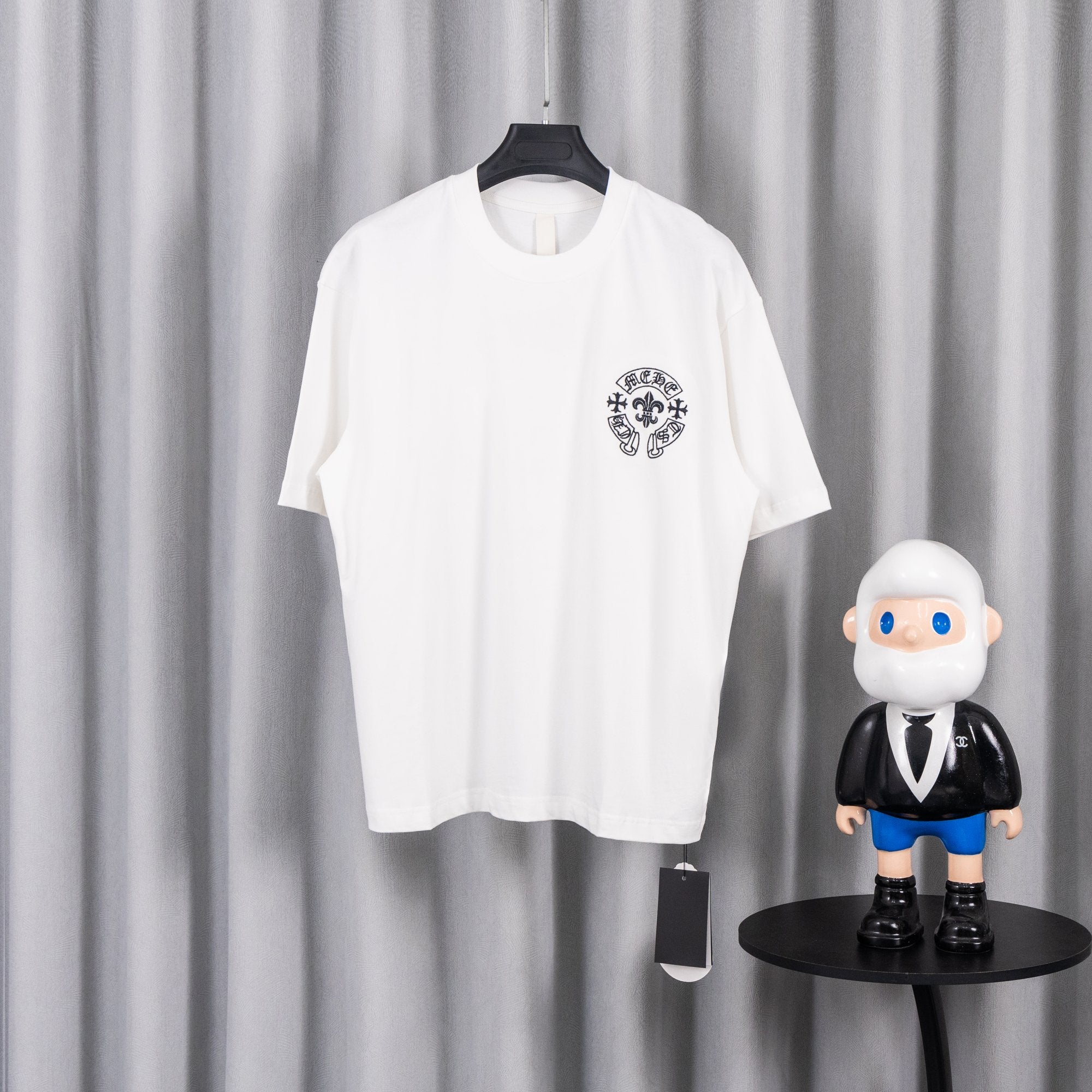 White short-sleeve graphic T-shirt with small chest crest logo