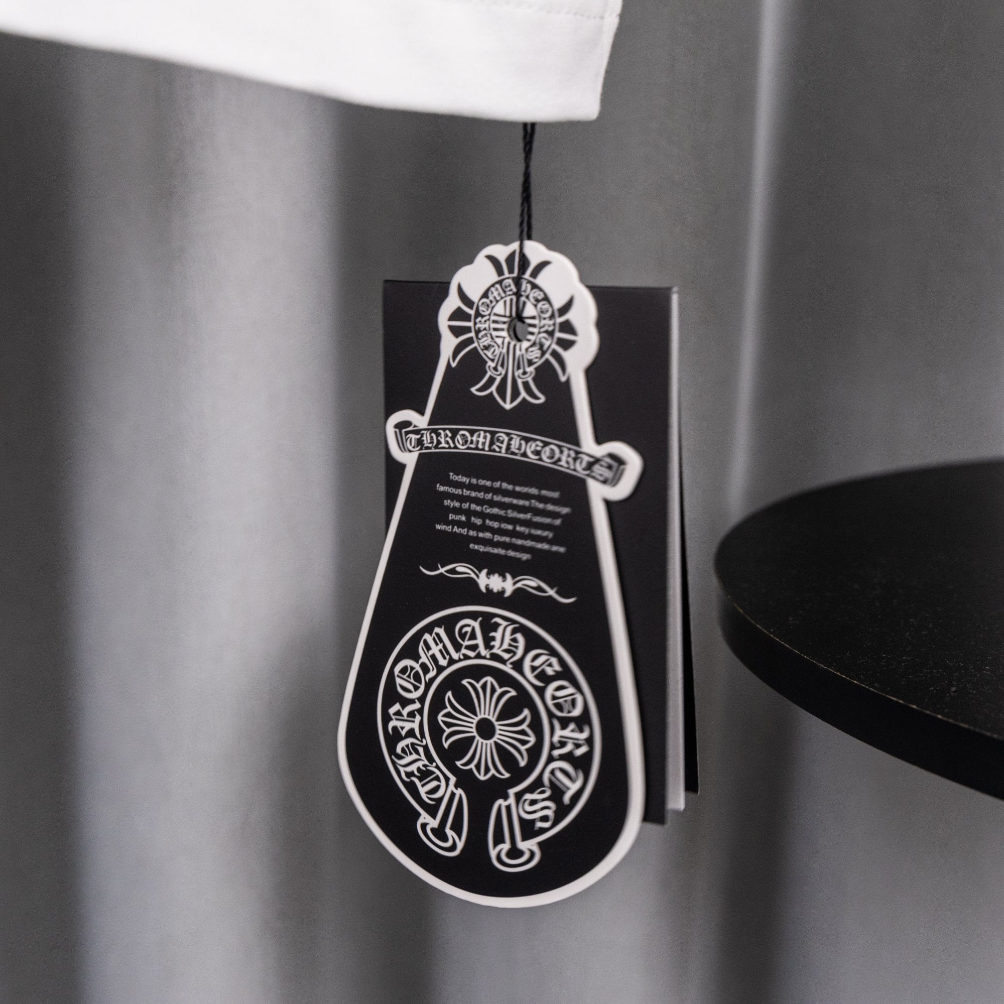 Hanging apparel tag on white graphic T-shirt with black logo print
