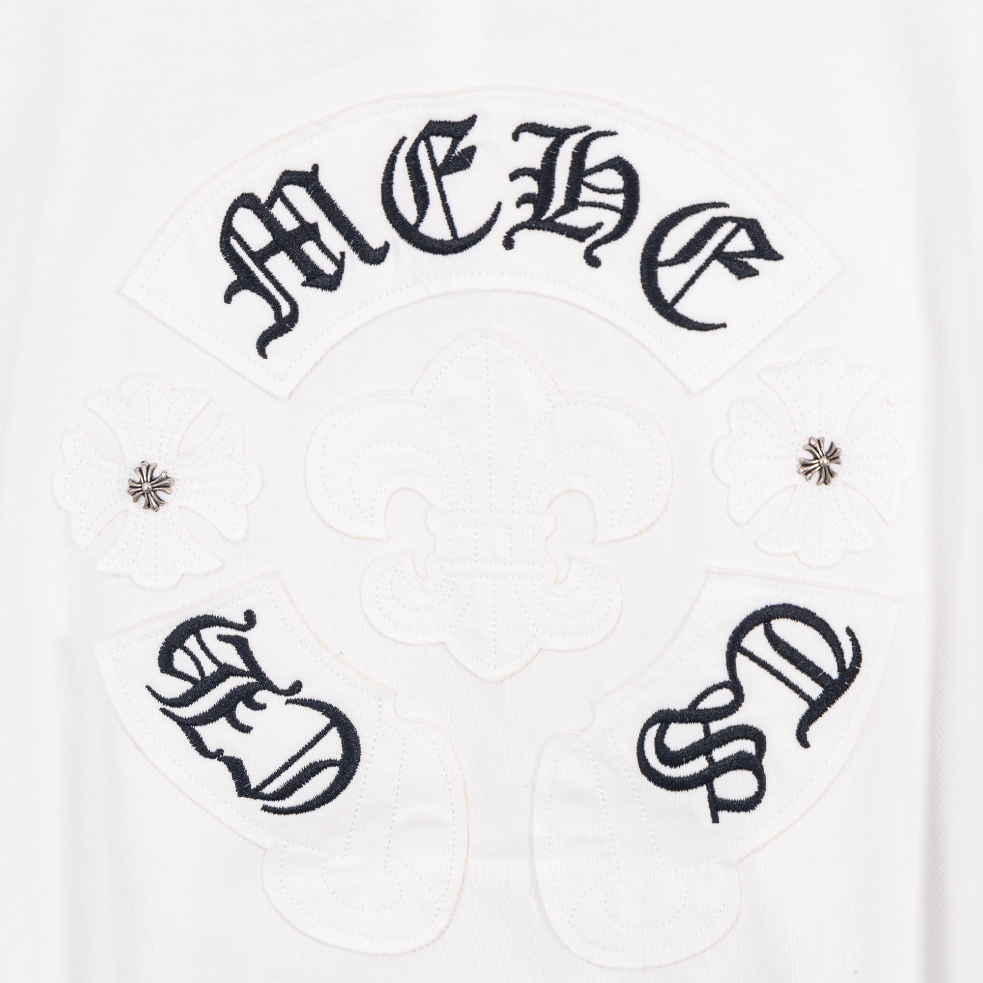 White T-shirt with dark decorative emblem panel and symbols