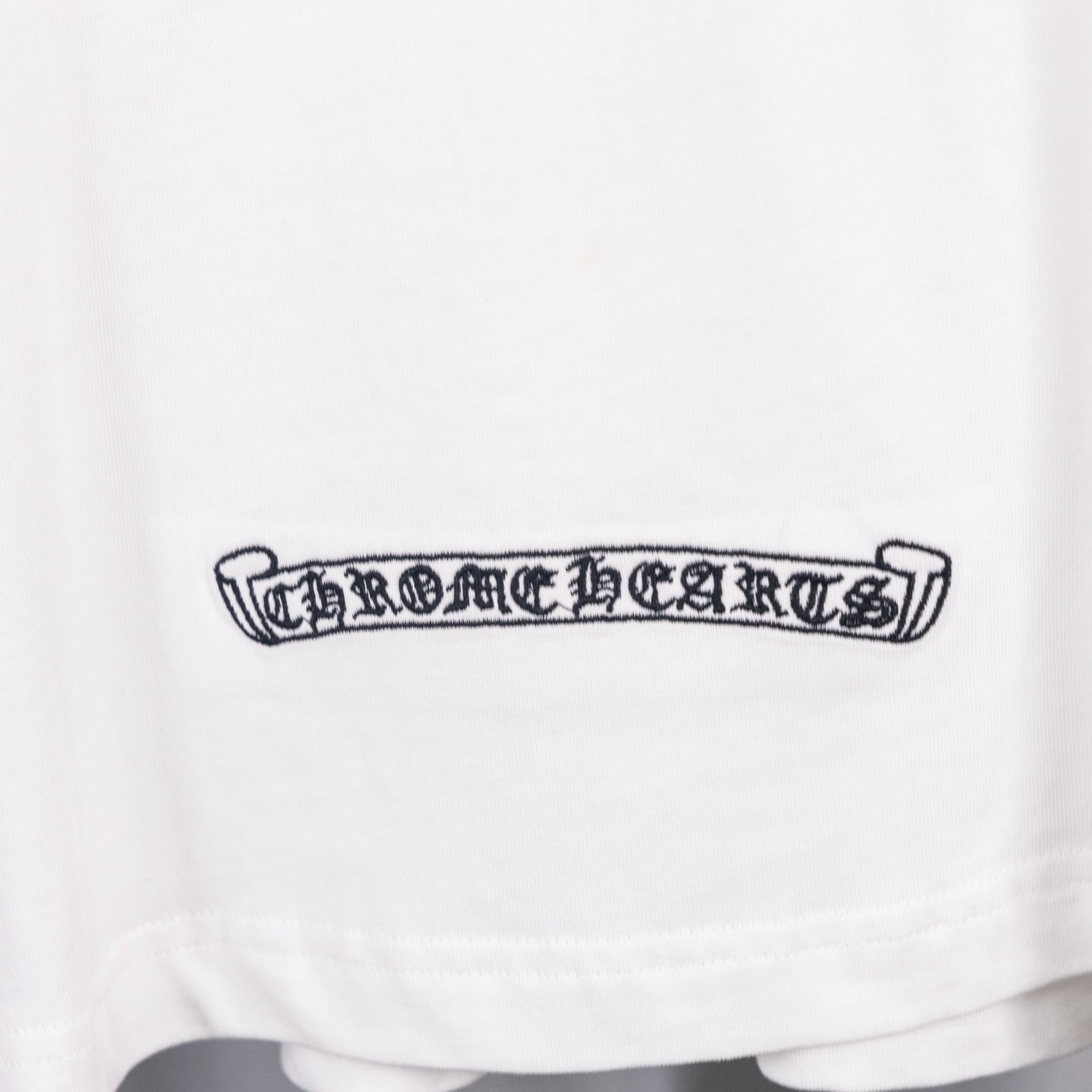 White T-shirt with dark horizontal logo patch on lower front