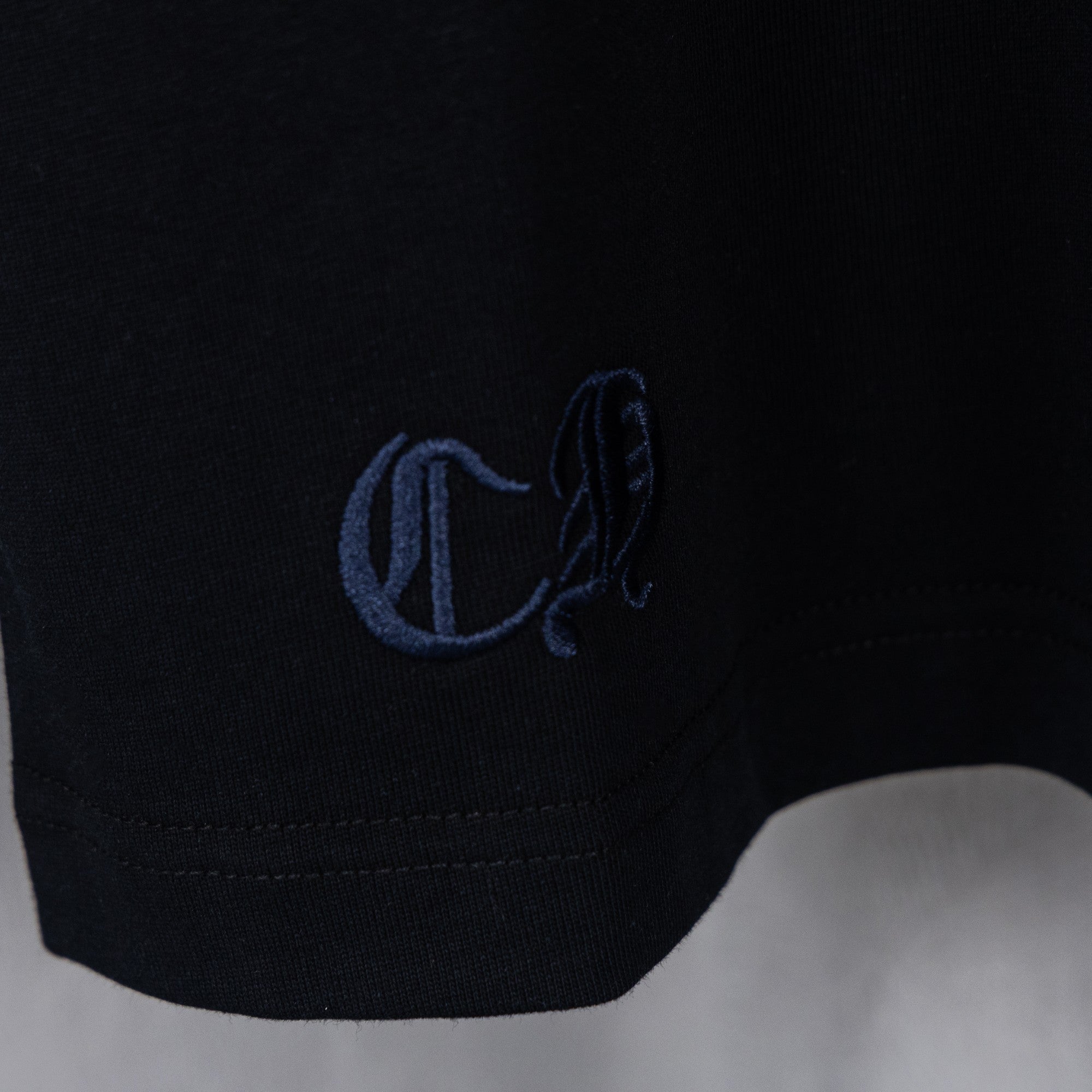 Black T-shirt sleeve cuff with blue embroidered logo