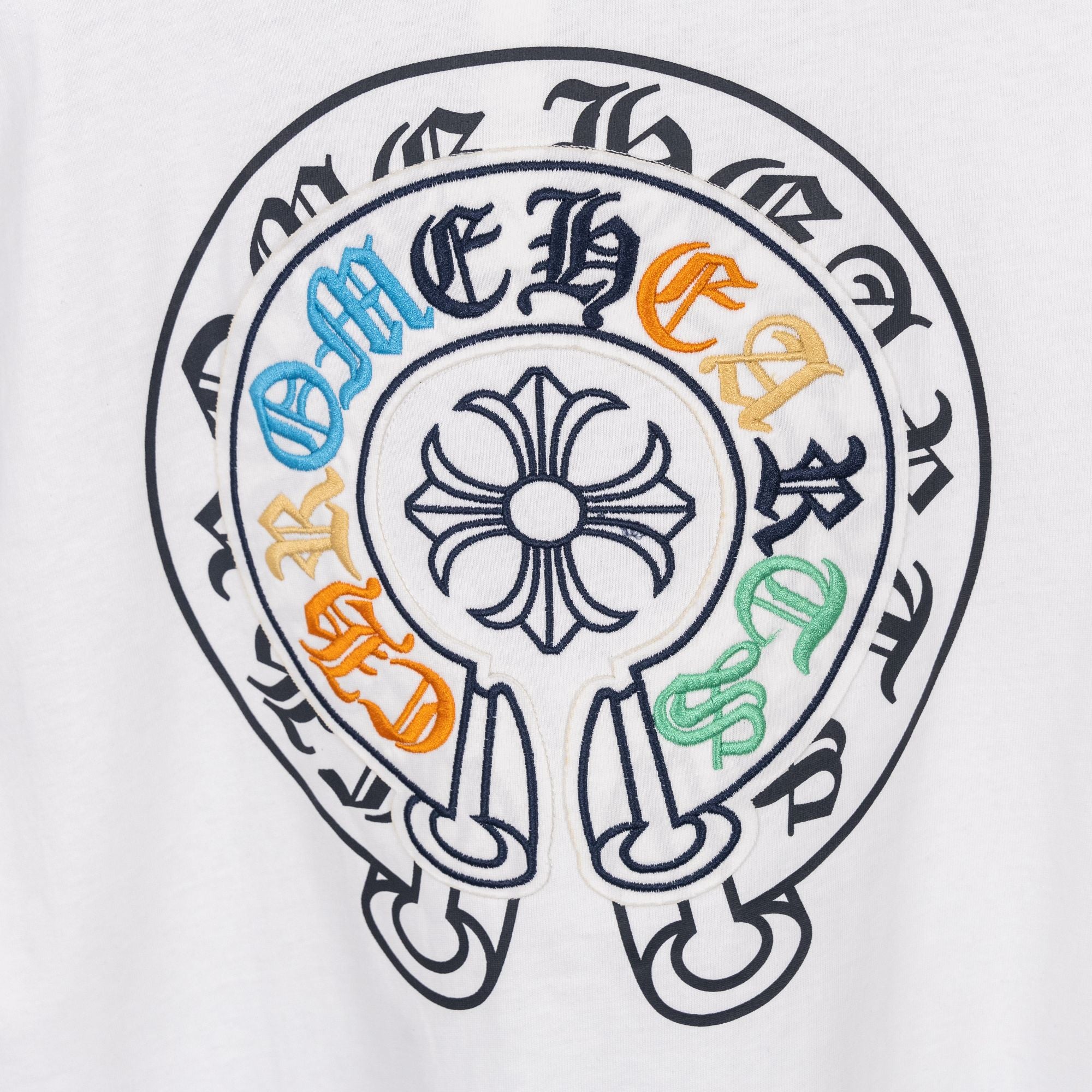White T-shirt circular embroidered crest graphic with multicolor accents