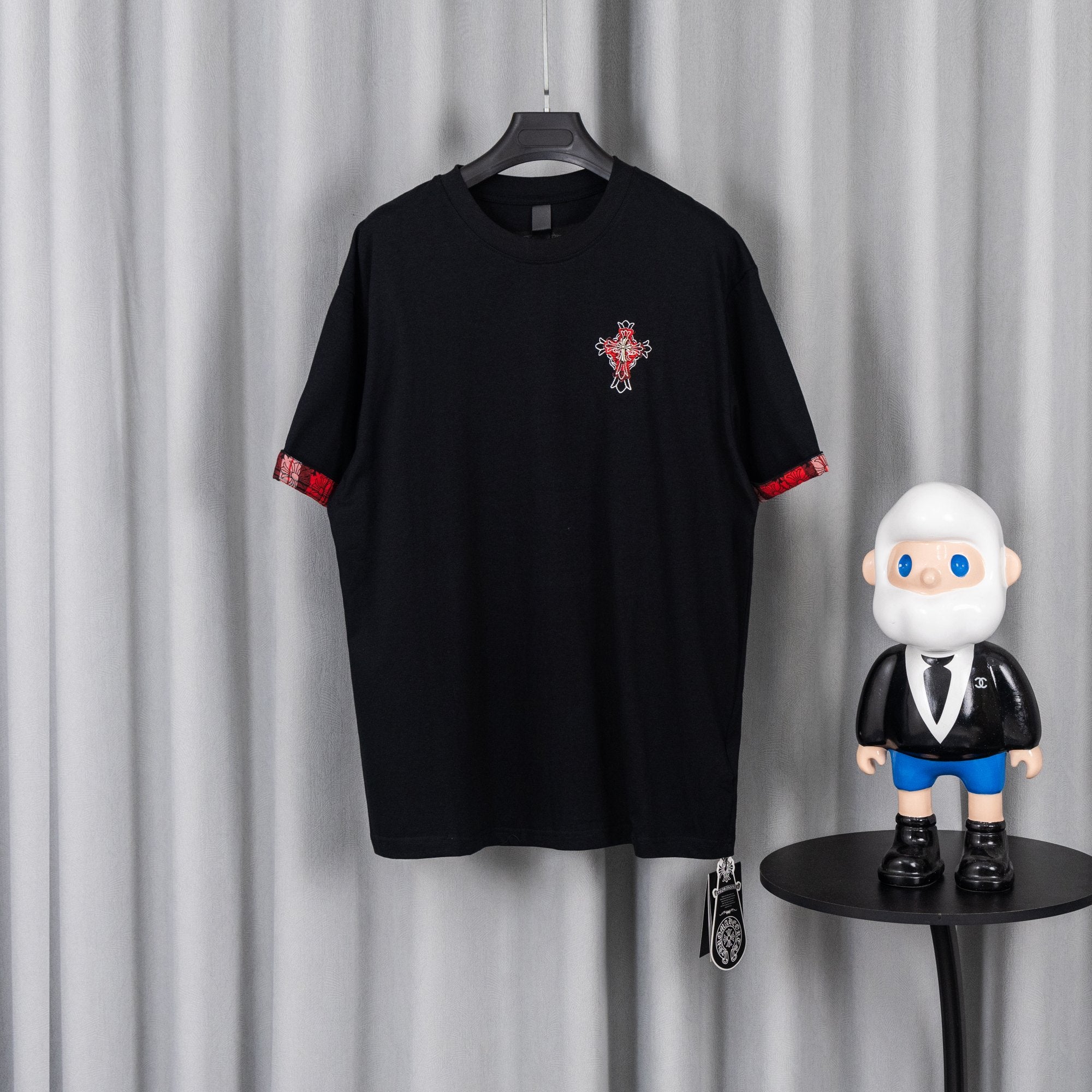 Black short-sleeve T-shirt with red trim cuffs and small chest graphic patch