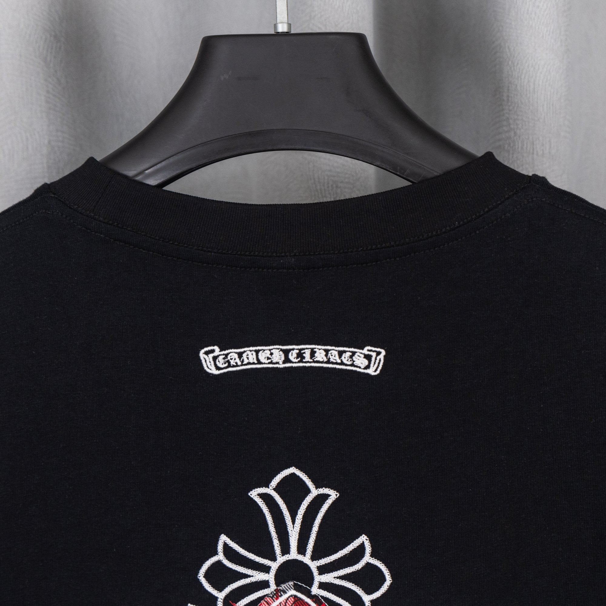 Black T-shirt neckline with white and red chest logo graphic