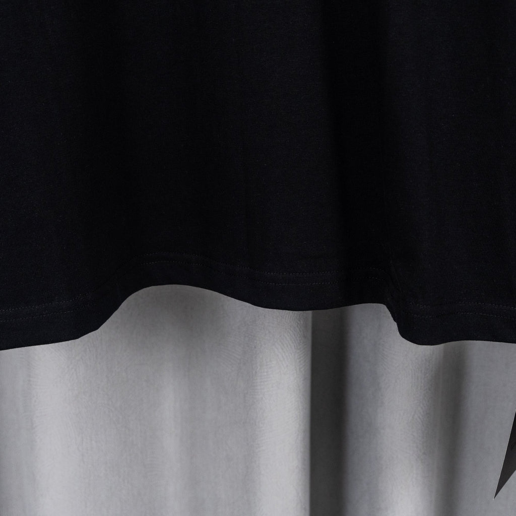 Black T-shirt lower hem with slight drape and clean stitched edge