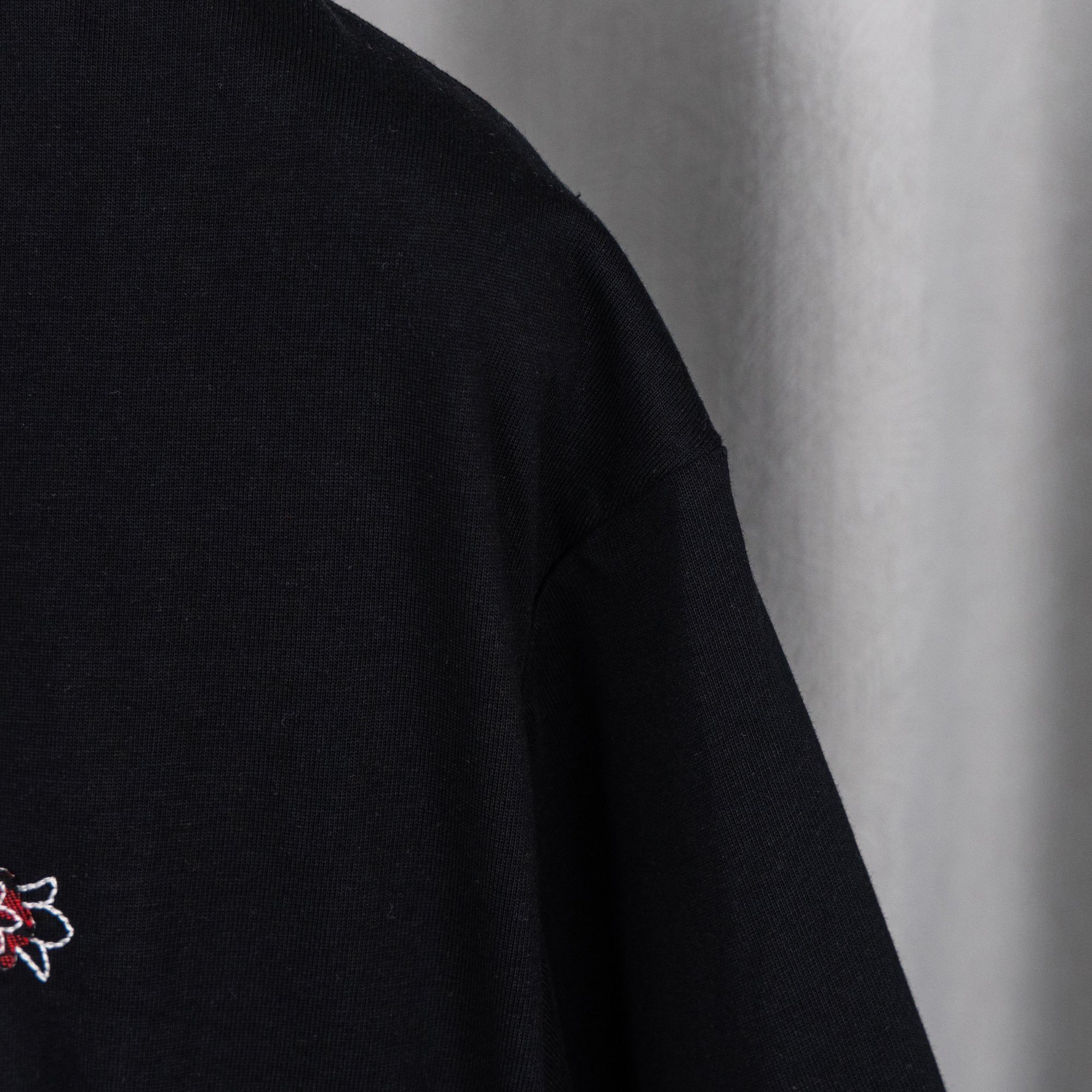 Black short-sleeve T-shirt with small embroidered emblem and sleeve