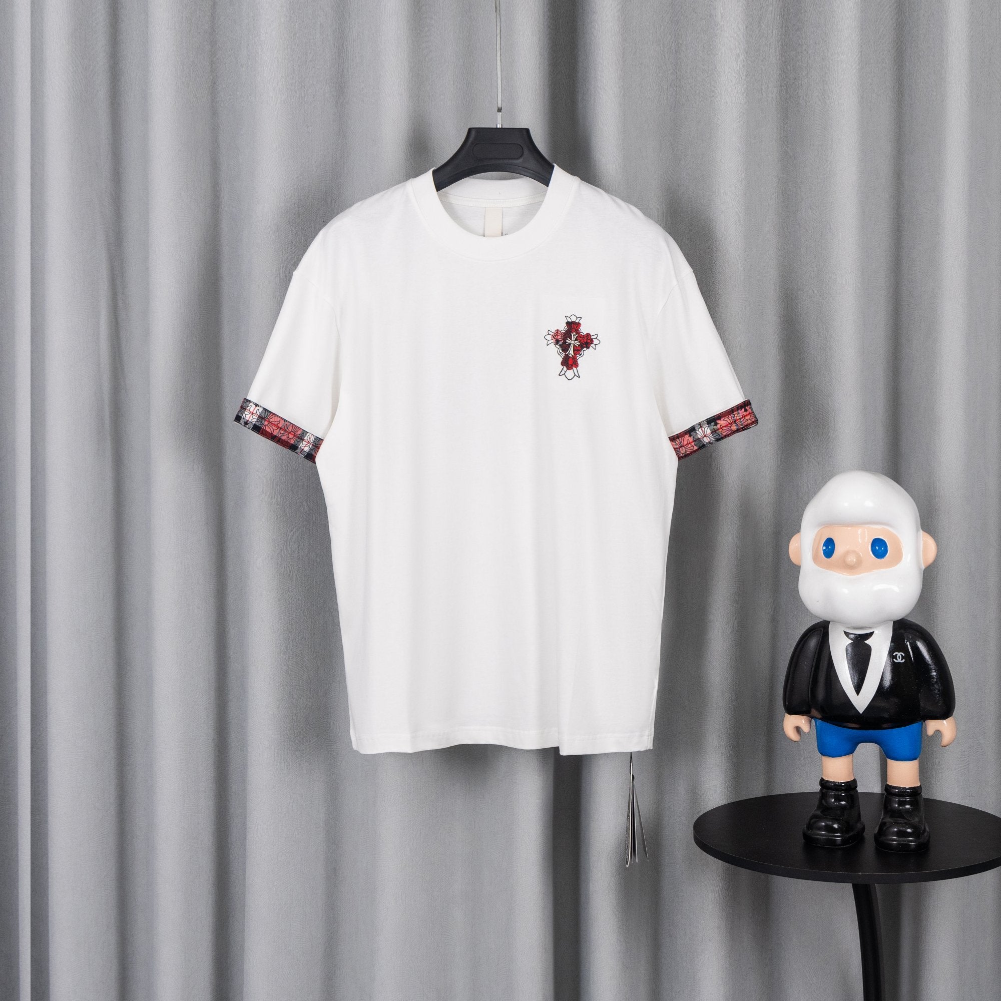 White crew-neck short-sleeve T-shirt with red plaid graphic on chest and sleeve trim