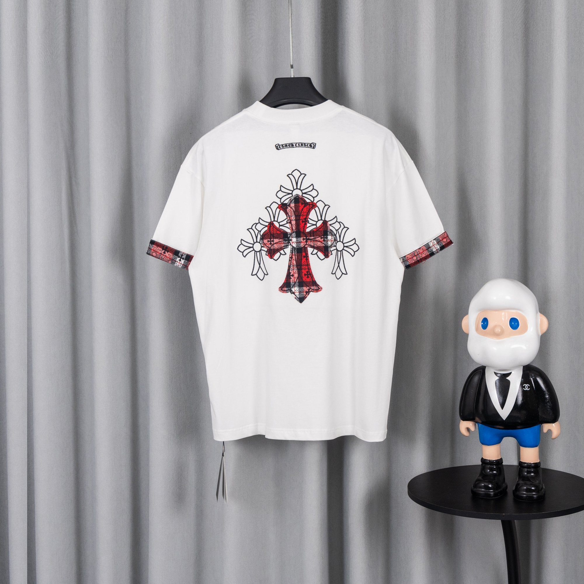 White crew-neck short-sleeve T-shirt with large back cross graphic and plaid sleeve trim