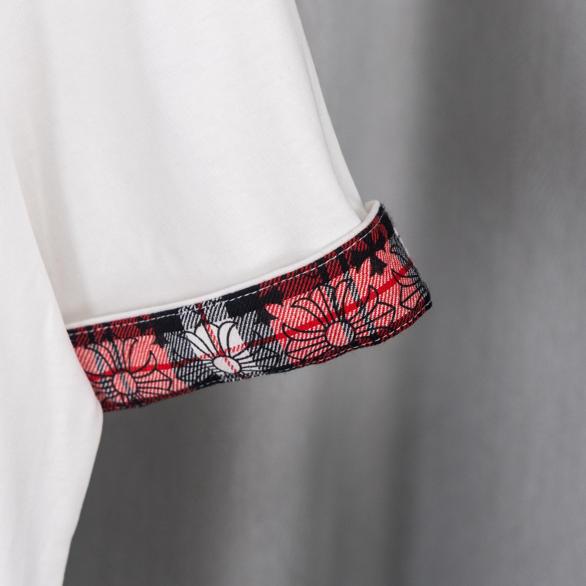White T-shirt sleeve with red black plaid cuff trim